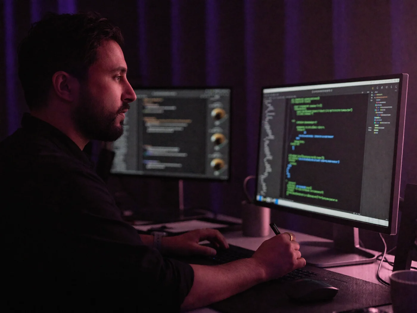 Nikhil Sharma writing code across two monitors
